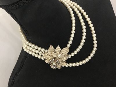 Sale Photo Thumbnail #102: A vintage triple-strand faux pearl necklace featuring an elaborate side clasp decorated with beaded seed pearls and aurora borealis rhinestones in a floral motif. Marked "JAPAN" on the back of the metal setting. Shows light age-appropriate wear, including