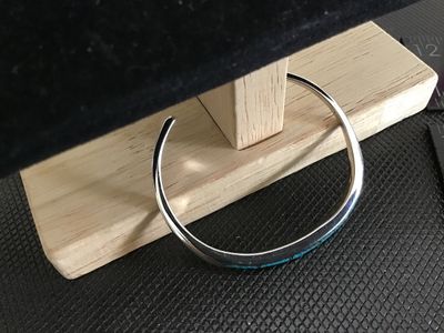 Sale Photo Thumbnail #169: Slim silver cuff bracelet featuring crushed turquoise channel inlay along the top edge. Measures approximately 2.5 inches wide with an open gap for easy wear. In good condition with minimal surface wear.