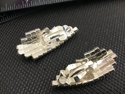 Sale Photo Thumbnail #205: Pair of vintage silver-tone clip-on earrings set with sparkling multi-tiered clear rhinestones. Curved leaf or wing-style design. Each earring measures approximately 1.5 inches long. Clip backs are in functional condition with bright, clear stones.