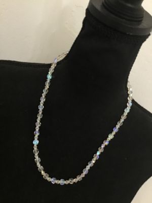 Sale Photo Thumbnail #118: A vintage single-strand necklace featuring faceted clear glass beads with an iridescent Aurora Borealis (AB) coating. The necklace is finished with a filigree push-in box clasp. Appears to be in good vintage condition with no missing beads observed.