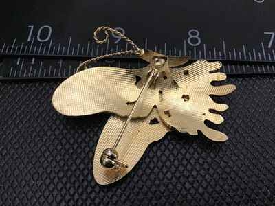 Sale Photo Thumbnail #55: A vintage gold-tone cloisonné enamel butterfly brooch pin featuring floral motifs on the wings in shades of blue, white, gold, green, and red. The back features a textured gold-tone finish with a standard pin stem and rollover safety clasp in working con