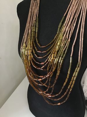 Sale Photo Thumbnail #122: Multi-strand statement necklace featuring earth-toned amber and honey-colored glass bugle beads layered with natural light brown heishe/stone beads. Finished with textured metal end cones and an adjustable hook-and-chain closure. Appears to be in very goo