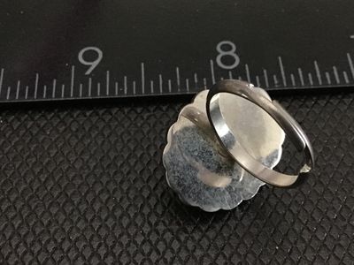 Sale Photo Thumbnail #143: Vintage statement ring featuring an oval green, black, and multicolor art glass cabochon set in a scalloped, rope-twist silver tone bezel. The ring has an adjustable band as shown in the photos. Measures approximately size 8 to 9 as shown on the ring size