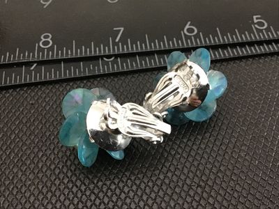 Sale Photo Thumbnail #27: Pair of vintage floral-form clip-on earrings featuring iridescent light blue petals, faux pearl clusters, and small spacer beads. Silver-tone clip backs are marked "JAPAN". Measure approximately 1 inch in diameter. Good vintage condition with light age-ap