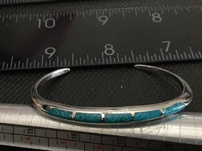 Sale Photo Thumbnail #171: Slim silver cuff bracelet featuring crushed turquoise channel inlay along the top edge. Measures approximately 2.5 inches wide with an open gap for easy wear. In good condition with minimal surface wear.