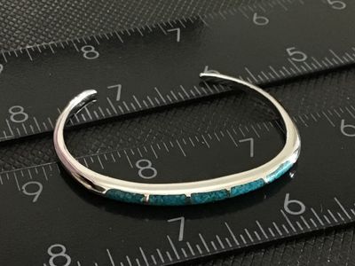 Sale Photo Thumbnail #168: Slim silver cuff bracelet featuring crushed turquoise channel inlay along the top edge. Measures approximately 2.5 inches wide with an open gap for easy wear. In good condition with minimal surface wear.