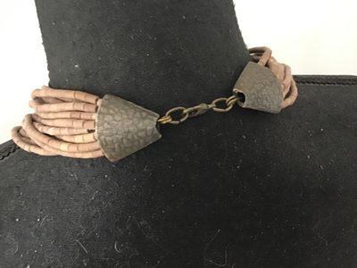 Sale Photo Thumbnail #124: Multi-strand statement necklace featuring earth-toned amber and honey-colored glass bugle beads layered with natural light brown heishe/stone beads. Finished with textured metal end cones and an adjustable hook-and-chain closure. Appears to be in very goo