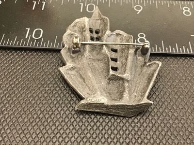 Sale Photo Thumbnail #75: A unique vintage pewter brooch by DAJO featuring a stylized, dimensional city skyline / cityscape with detailed architectural buildings. Signed DAJO on the back with a standard pin stem and rollover clasp. Measures approximately 2 inches tall by 2 inches 