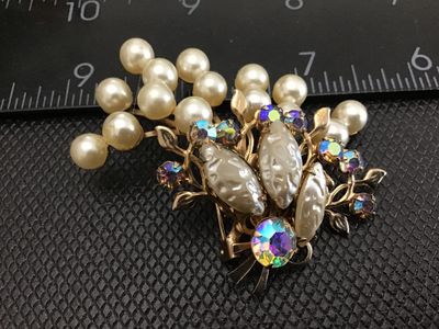 Sale Photo Thumbnail #18: Vintage gold-tone brooch pin featuring faux pearl clusters, textured molded cabochons, and shimmering aurora borealis (AB) rhinestones in a stylized floral spray design. Standard rollover safety clasp on the back. Measures approximately 2.5 inches wide. G