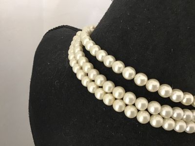 Sale Photo Thumbnail #103: A vintage triple-strand faux pearl necklace featuring an elaborate side clasp decorated with beaded seed pearls and aurora borealis rhinestones in a floral motif. Marked "JAPAN" on the back of the metal setting. Shows light age-appropriate wear, including