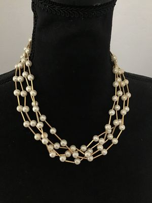 Sale Photo Thumbnail #105: A multi-strand vintage costume necklace featuring cream-colored faux pearls interspersed with gold-tone rigid bar links, creating a dramatic structured lattice or cage effect. Secured with a spring-ring clasp. Shown on a jewelry display bust and alongside