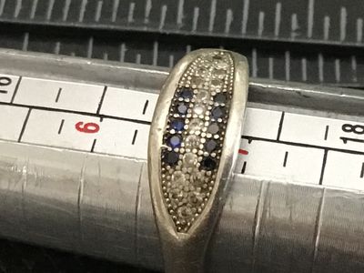 Sale Photo Thumbnail #62: Sterling silver band ring featuring a pavé-set top face with rows of blue and clear rhinestones/cz stones. Stamped 925 on the interior band. Measures approximately ring size 6 on a ring mandrel. Shows light surface wear and minor tarnishing consistent wi