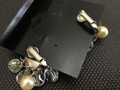 Sale Photo Thumbnail #23: Pair of vintage clip-on cluster earrings featuring central faux pearl cabochons framed by silver-tone filigree metalwork, surrounded by dangling faceted clear crystal beads and smaller accent faux pearls. Measure approximately 1.25 inches across. Shows mi