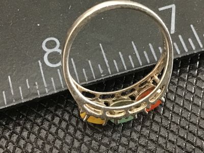 Sale Photo Thumbnail #199: Sterling silver band featuring three oval cabochons in yellow, green, and orange/red tones, possibly multi-colored jade or chalcedony. Inner band is stamped with a maker mark and sterling/925 purity mark. Measures approximately size 7.5 on a ring sizer. S