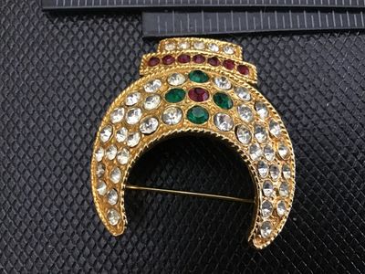Sale Photo Thumbnail #39: Vintage gold-tone crescent moon shaped brooch set with clear, green, and red rhinestones. Features a textured finish and a standard pin back fastener. Measures approximately 1.5 inches in length. In good vintage condition with all stones intact.