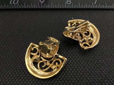 Sale Photo Thumbnail #158: Pair of vintage fan-shaped clip-on earrings featuring gold-tone metal, black enamel accents, scrollwork detailing, and clear rhinestones. Each earring measures approximately 1 inch across. Clip-on backs are functional and intact. In good vintage condition