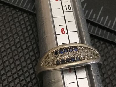 Sale Photo Thumbnail #63: Sterling silver band ring featuring a pavé-set top face with rows of blue and clear rhinestones/cz stones. Stamped 925 on the interior band. Measures approximately ring size 6 on a ring mandrel. Shows light surface wear and minor tarnishing consistent wi