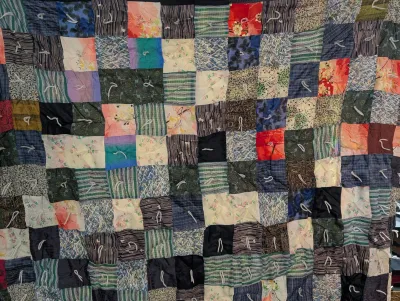 Sale Photo Thumbnail #93: Handmade patchwork quilt crafted from assorted vintage fabric squares with white yarn ties throughout.