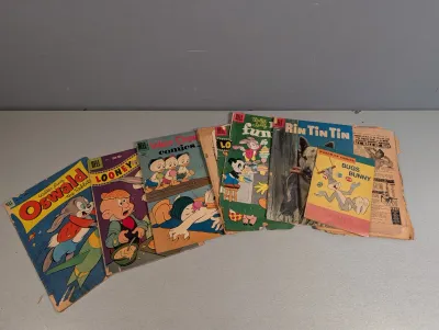 Sale Photo Thumbnail #378: Collection of vintage Dell comic books featuring characters like Oswald the Rabbit, Looney Tunes, Walt Disney's Comics, and Rin Tin Tin.