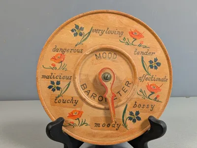 Sale Photo Thumbnail #218: Vintage novelty wooden 'Mood Barometer' plaque featuring hand-painted floral motifs and various emotion labels with a movable pointer.