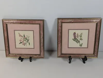 Sale Photo Thumbnail #123: Pair of framed botanical prints featuring pink and purple wildflowers, housed in matching mauve marbled and gold-tone trim frames with pink matting.