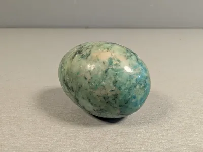 Sale Photo Thumbnail #313: Smooth polished turquoise and green marbled stone egg specimen.