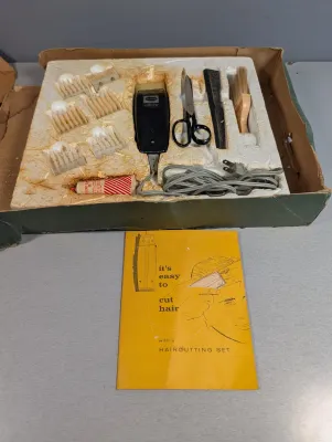 Sale Photo Thumbnail #372: Vintage electric home haircutting kit in original styrofoam insert box, including clippers, attachments, scissors, comb, brush, and instruction booklet.