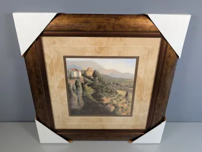 Sale Photo Thumbnail #445: Framed Tuscan landscape print in a dark wood and metallic bronze frame with protective cardboard corners.