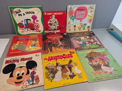 Sale Photo Thumbnail #182: Collection of vintage children's vinyl records and read-along story albums, featuring Disney titles like The Aristocats, Mickey Mouse, and Donald Duck alongside Sesame Street and Davy Crockett.