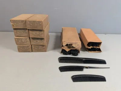 Sale Photo Thumbnail #369: Vintage lot of Vulco black plastic hair combs, featuring multiple boxed dozen sets alongside sample dressing, rat tail, and pocket combs.