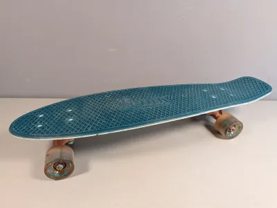 Sale Photo Thumbnail #32: Penny Australia blue plastic cruiser skateboard featuring translucent wheels with shark graphics and light signs of wear.