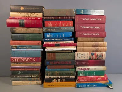 Sale Photo Thumbnail #231: Three large stacks of vintage hardcover books, including classic fiction, non-fiction, and reference titles, showing moderate wear on spines and dust jackets.