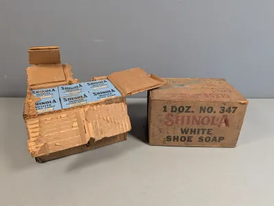 Sale Photo Thumbnail #373: Vintage Shinola White Shoe Soap shipping boxes, including one open box filled with individual light blue soap packages.