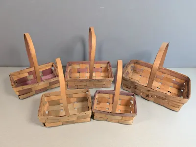 Sale Photo Thumbnail #222: Collection of five vintage woven splint market baskets with fixed overhead handles, featuring natural and stained wood strips.
