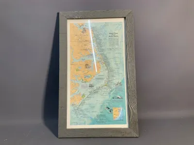 Sale Photo Thumbnail #75: Framed 'Ghost Fleet of the Outer Banks' shipwreck map in a weathered grey rustic wood frame.