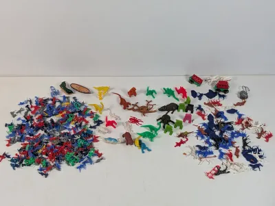 Sale Photo Thumbnail #101: Large collection of vintage colorful plastic toy figures, including army men, dinosaurs, and animals, spread out on a white surface.