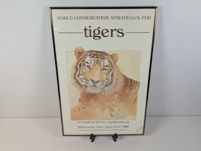Sale Photo Thumbnail #124: Framed 1986 poster for the World Conservation Strategies for Tigers International Symposium at the Minnesota Zoo, featuring a tiger illustration and metallic metal frame.