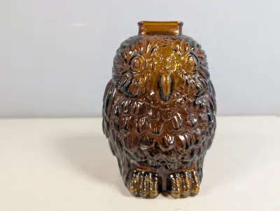 Sale Photo Thumbnail #295: Vintage amber glass owl-shaped bottle or vase featuring detailed textured feather patterning.