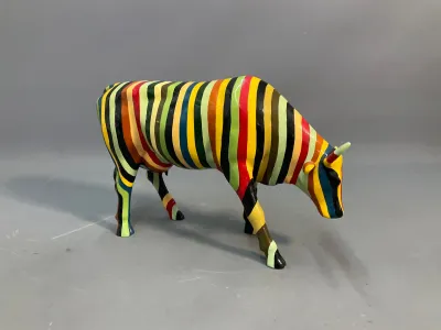 Sale Photo Thumbnail #70: CowParade painted resin cow figurine featuring vibrant multi-colored vertical stripes. Glossy finish and intact condition.