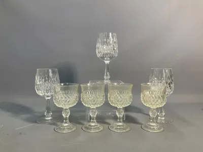 Sale Photo Thumbnail #88: Seven vintage clear cut-crystal goblets and wine glasses featuring diamond-patterned bowls and faceted stems.