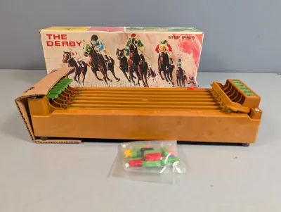 Sale Photo Thumbnail #232: Vintage Bandai 'The Derby' battery-operated horse racing game with original box and plastic horse game pieces.