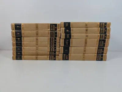 Sale Photo Thumbnail #96: Vintage multi-volume set of The American Educator encyclopedia with textured tan covers and gilded spine accents.