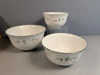 Sale Photo Thumbnail #41: Nesting set of three Pfaltzgraff Heritage Winterberry ceramic serving bowls featuring a festive holly and berry pattern with green trim.