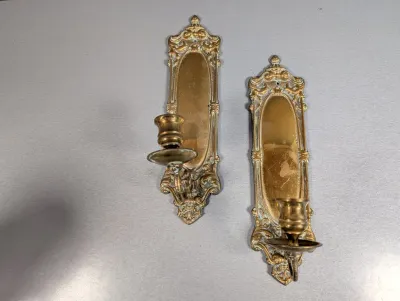 Sale Photo Thumbnail #45: Pair of vintage French Rococo-style brass wall sconces featuring ornate scrollwork frames and mirrored backings.