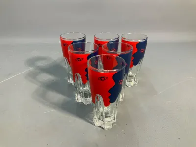 Sale Photo Thumbnail #85: Set of six vintage shot glasses featuring red and blue pop art face motifs on clear glass.