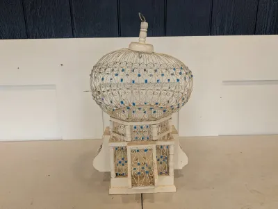 Sale Photo Thumbnail #488: Vintage white wire and wooden architectural decorative birdcage featuring an onion-dome top and small blue painted accents.