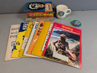 Sale Photo Thumbnail #273: Collection of vintage Boy Scouts and Cub Scouts memorabilia, including handbooks, Scouting magazines, a Tidewater Council Camporee mug, and embroidered patches.