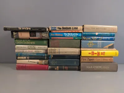 Sale Photo Thumbnail #235: Large collection of vintage hardcover and paperback books organized in three stacks, featuring historical non-fiction, biographies, and fiction titles.