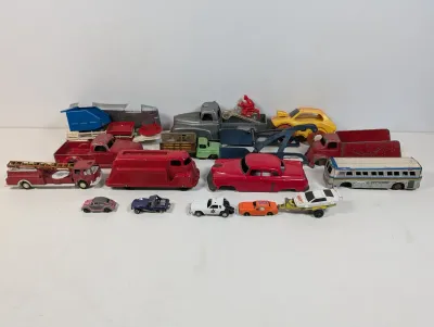 Sale Photo Thumbnail #110: Collection of vintage die-cast and cast-iron toy vehicles, including trucks, fire engines, emergency vehicles, and classic cars showing varying degrees of wear.