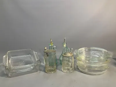 Sale Photo Thumbnail #67: Collection of vintage glassware items including Pyrex baking dishes, oil and vinegar cruets, and two glass beer steins with pewter lids.